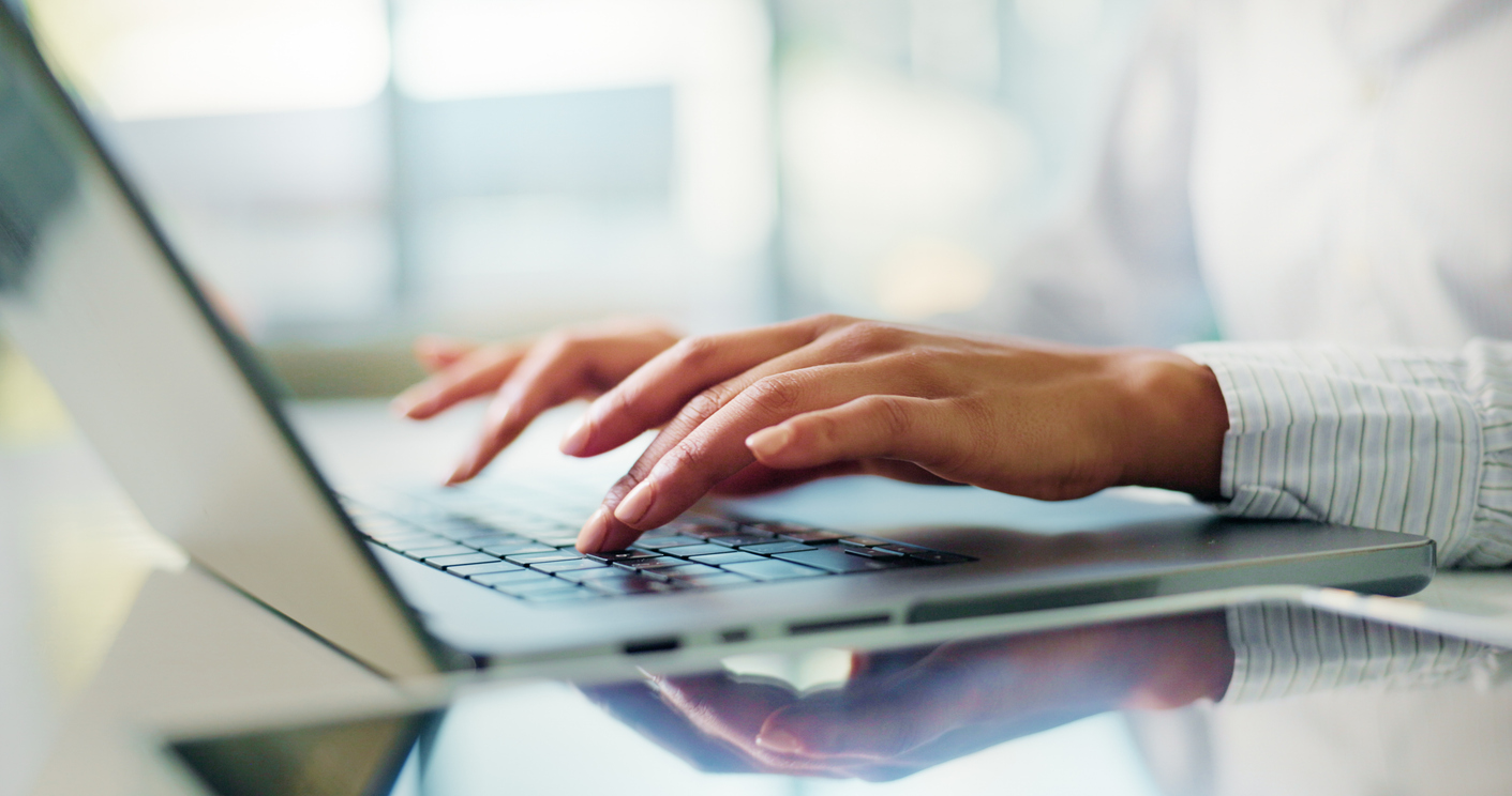 Hands, typing and laptop