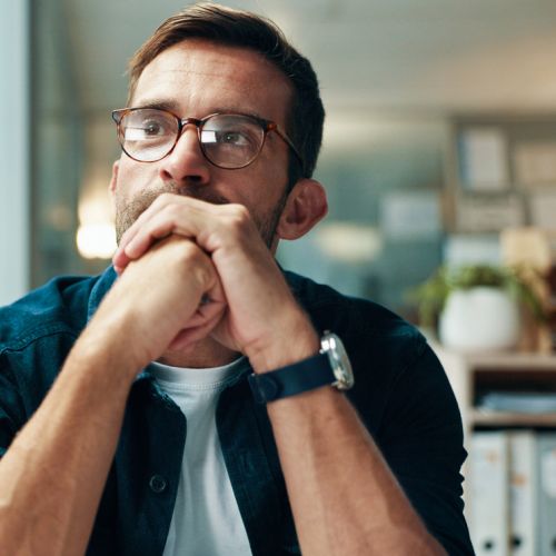 Man with hands clasped while thinking